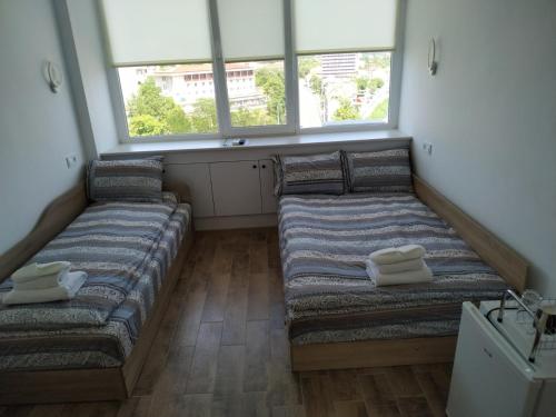 two beds in a room with two windows at Top Center Nice View Studio in Gabrovo