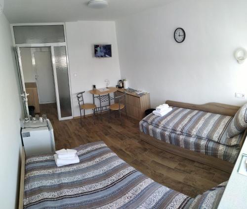 una habitación de hotel con dos camas y una mesa en Top Center Nice View Studio, en Gabrovo