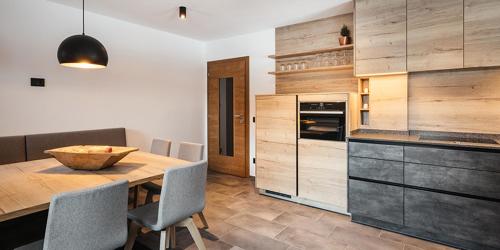 eine Küche mit einem Holztisch und einigen Stühlen in der Unterkunft Hotel Alcialc in Wengen