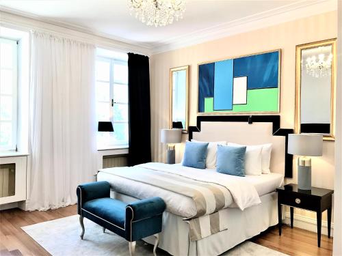 Luxury Suites & Apartments MONDRIAN Market Square II في وارسو: غرفة نوم بسرير كبير وكرسي ازرق