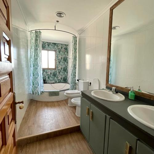 a bathroom with a sink and a toilet and a mirror at Los Manantiales Casa Rural in Alcaraz
