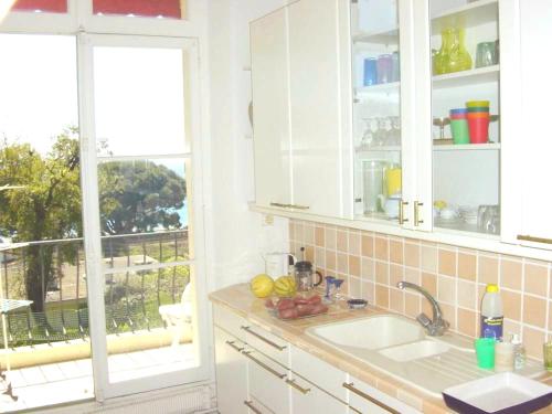 une cuisine avec un évier et une fenêtre dans l'établissement Appartement moderne à Cannes avec vue sur mer et montagne - 85 m², à Cannes