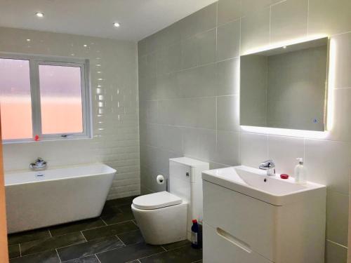 uma casa de banho com um lavatório, uma banheira e um WC. em Culduthel Cottage em Inverness