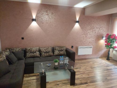 a living room with a couch and a glass table at Family Hotel Gotse Delchev in Gotse Delchev
