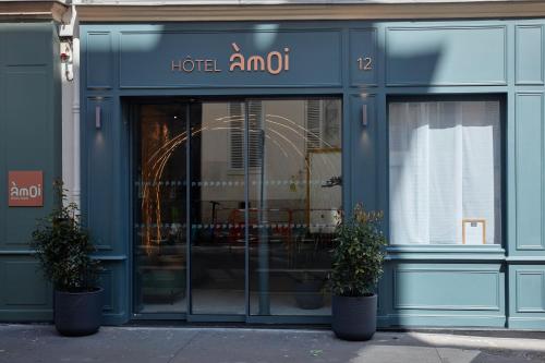 Hôtel Amoi Paris في باريس: واجهة الفندق رائعة مع اثنين من النباتات الفخارية في الأمام