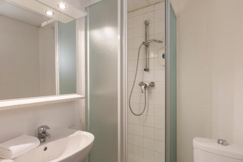 ein Bad mit einer Dusche und einem Waschbecken in der Unterkunft Hôtel F1 Reims Tinqueux in Reims