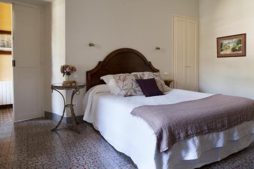 a bedroom with a large white bed and a table at B&B Can Casadella in Premia de Dalt