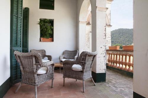 a patio with wicker chairs and a table on a balcony at B&B Can Casadella in Premia de Dalt