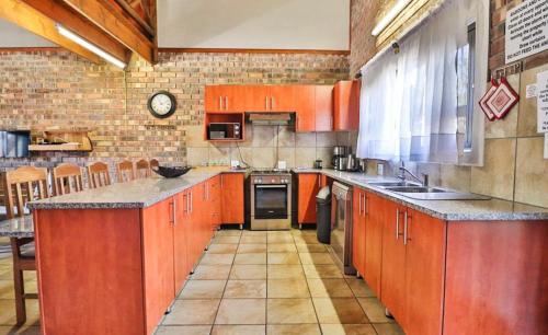 a large kitchen with orange cabinets and a counter at Nghala Self-catering Holiday Home in Marloth Park