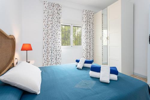 um quarto com uma cama azul e almofadas brancas em Casa rural El Polvillar / Piscina privada em Alora