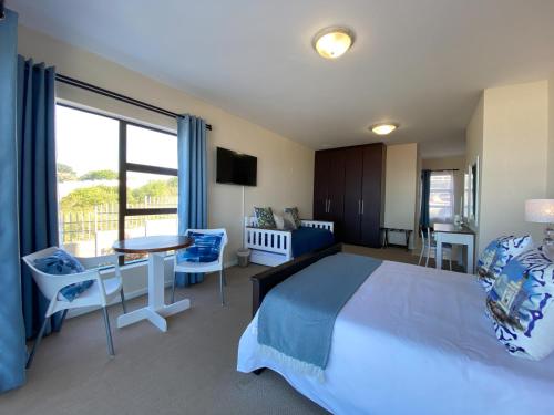 a bedroom with a large bed and a table and chairs at Blue Star Villa in Tergniet