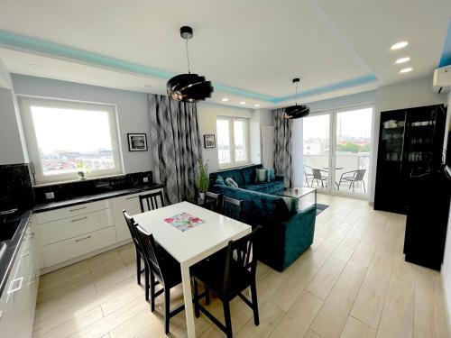 a kitchen and living room with a table and a couch at Apartament z tarasem i widokiem na Odrę in Wrocław