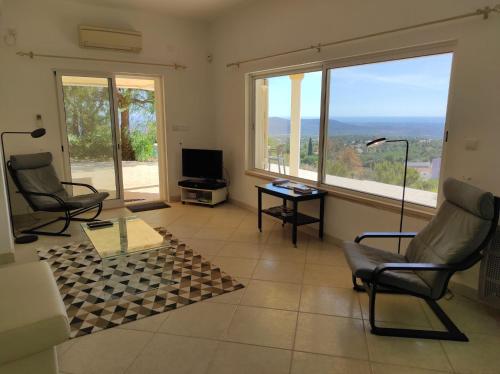a living room with two chairs and a large window at Villa 3 Quartos, Piscina, AC, Vista Mar, Prestige For Home in Loulé