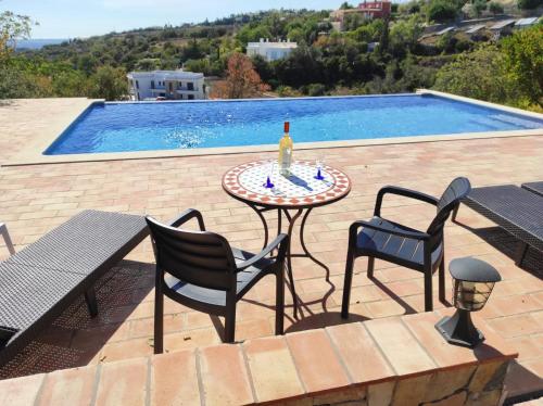 una mesa con una botella de vino junto a una piscina en Loulé - Poço Geraldo en Loulé