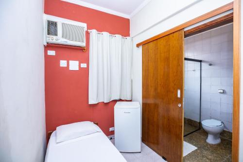 a small bathroom with a bed and a toilet at Hotel Venice Ubatuba in Ubatuba