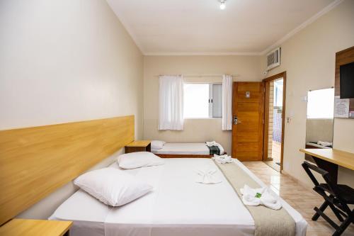 a bedroom with a bed and a desk in it at Hotel Venice Ubatuba in Ubatuba