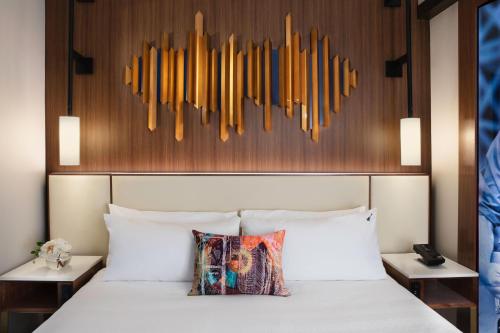 a bedroom with a white bed with a wooden headboard at Hard Rock Hotel New York in New York
