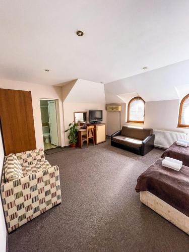 ein Wohnzimmer mit einem Bett und einem Sofa in der Unterkunft Family Hotel Palermo in Tutrakan