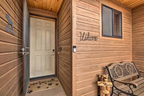 a wooden cabin with a door and a bench at Deck and Views Dog-Friendly Cabin in Show Low! in Show Low