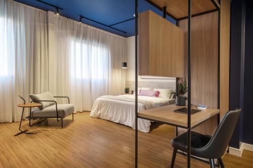 ポルト・アレグレにあるSwan Generation Porto Alegreのベッドルーム1室(ベッド1台、テーブル、椅子付)