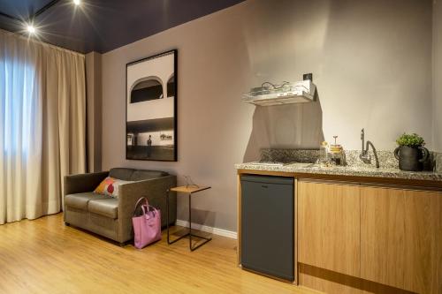 a living room with a chair and a counter at Swan Generation Porto Alegre in Porto Alegre