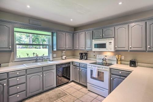 a kitchen with gray cabinets and white appliances at Private Dock and Slip Cedar Creek Reservoir Home in Mabank