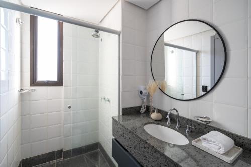 a bathroom with a sink and a mirror at Swan Generation Porto Alegre in Porto Alegre