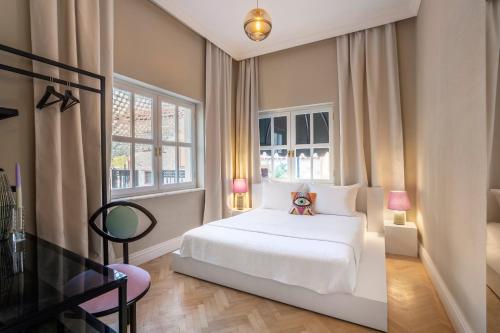1 dormitorio con 1 cama blanca y 2 ventanas en House of Good Things, en Antalya