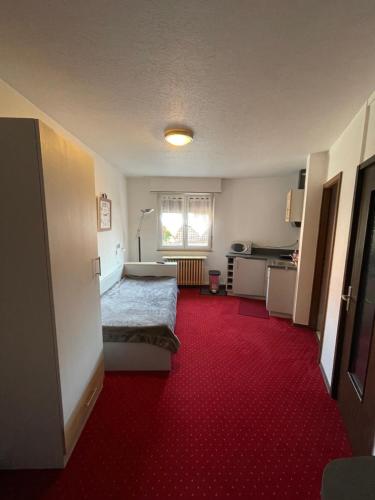 Schlafzimmer mit einem Bett und einem roten Teppich in der Unterkunft Appartement à l'ange in Climbach