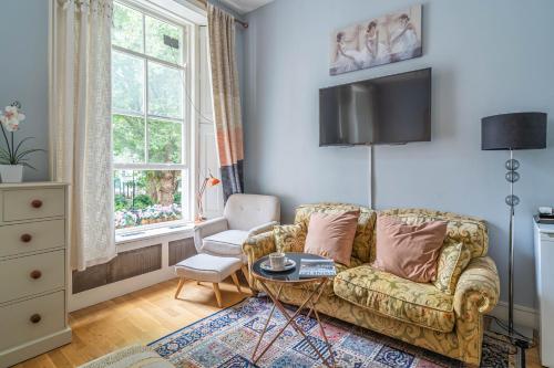a living room with a couch and a table at House close to kings cross in London