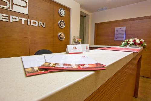 a reception desk in an office with flowers on it at Sofia Place Hotel by HMG in Sofia