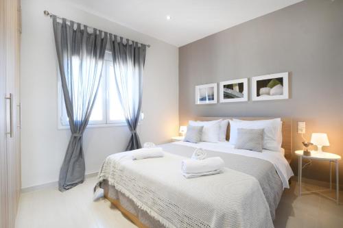 um quarto branco com uma cama grande e toalhas em Sunset Luxury Suite - Rooftop Apartment in the City Center em Heraclião