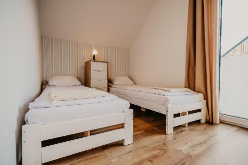 2 camas individuales en una habitación con ventana en Sun House en Nadole