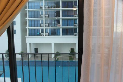 a balcony with a view of a building and a swimming pool at Cloud Stay at Setia Alam in Shah Alam