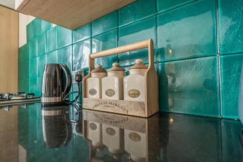 a kitchen counter with a group of bottles on it at House close to kings cross in London