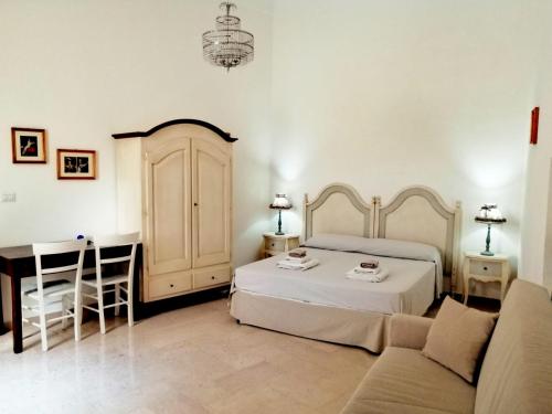 1 dormitorio con cama, mesa y sofá en Palazzo Cavoti, en Galatina