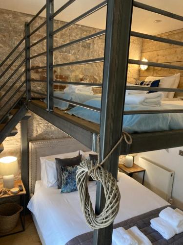 Een bed of bedden in een kamer bij ROYAL WILLIAM YARD Apartments "THE BRUCE" - BOOK either FAMILY APARTMENT king Bed, Triple Bunk Cabin & Sofa Bed - or SMALL FAMILY STUDIO twin bed mezzanine over KIng Bed - PRIVATE connecting lobby so BOOK BOTH For LARGER GROUPS - FREE ONSITE PARKING