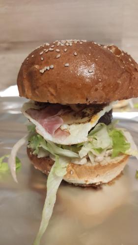 a sandwich with meat and lettuce on a bun at H@M Penzion in Žlutice