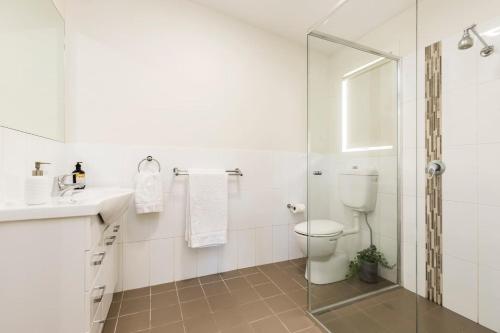 a bathroom with a toilet and a glass shower at 2 Bedroom w/Parking Near Central Cessnock in Cessnock