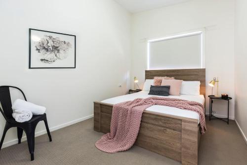 a bedroom with a large bed and a chair at 2 Bedroom w/Parking Near Central Cessnock in Cessnock