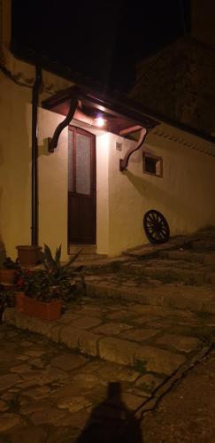 a small white building with a door at night at Casa borghetto in Cancellara