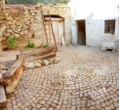 ceglany dziedziniec z ławką i budynek w obiekcie Casa borghetto w mieście Cancellara