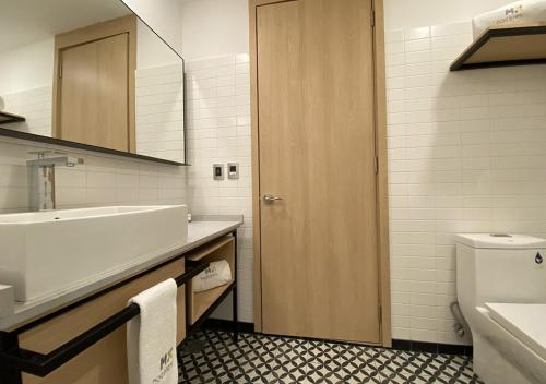 a bathroom with a sink and a toilet and a mirror at Hotel MX más san miguel de allende in San Miguel de Allende