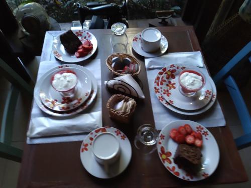 a wooden table with plates of food on it at Pousada da Terra Paraty in Paraty
