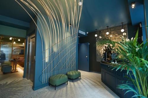 a lobby with blue walls and green stools at Hôtel Amoi Paris in Paris