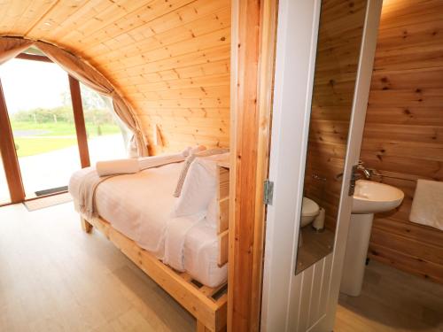 a bedroom with a bed in a wooden room at Pod 3 in Ballymoney