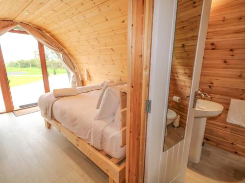 a bedroom with a bed in a wooden room at Pod 6 in Ballymoney