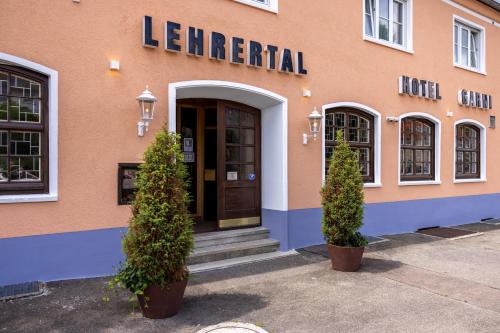 a building with a door and two trees in front at Hotel Garni Lehrertal in Ulm