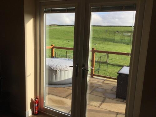 an open door to a balcony with a view of a pasture at Breeze Place in Nelson