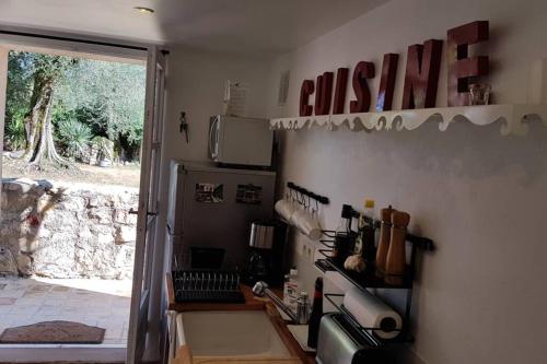 d'une cuisine avec cuisinière et d'une porte donnant sur une cour. dans l'établissement Studio indépendant dans mas provencal, à Le Rouret